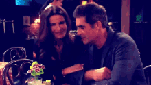 a man and a woman are sitting at a table with drinks