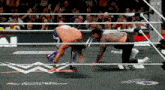 two men are wrestling in a ring with the word snickers on the floor