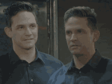 two men in black shirts are smiling for the camera