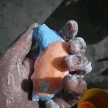 a person is holding a piece of soap in their hand covered in soap bubbles .