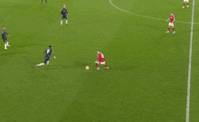 a group of soccer players on a field one of whom is wearing a red jersey