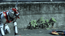a robot is crawling on the ground with a sword