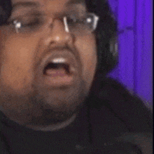a close up of a person wearing headphones and making a face .