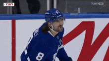 a hockey player wearing a blue jersey with the number 8