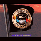 a black flag with a gold circle that says circle sound community