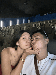 a man and a woman are posing for a picture in an empty auditorium