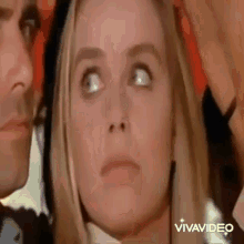 a man and a woman are standing next to each other and the woman is looking up at the camera .