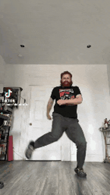 a man with a beard is dancing in a room with tiktok written on the bottom right