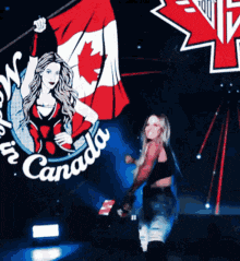 a woman stands in front of a sign that says " canada "