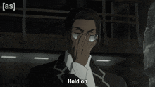 a man with glasses is covering his face with his hand and the words hold on are visible