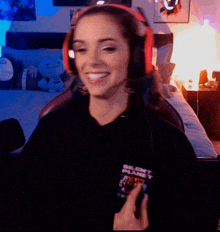 a woman wearing headphones and a silent planet shirt smiles
