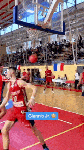 a basketball game is being played on a court in a gym with a crowd watching .