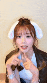 a woman wearing bunny ears is giving a thumbs up sign .