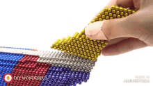 a person is playing with a bunch of colorful beads and the words diy wonderful are on the bottom