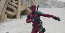 a man in a deadpool costume is holding a gun in his right hand