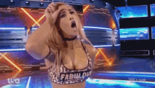 a woman in a leopard print top with the word fabulous on it is standing on a stage .
