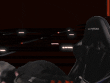 a man wearing headphones and glasses is sitting in a gaming chair
