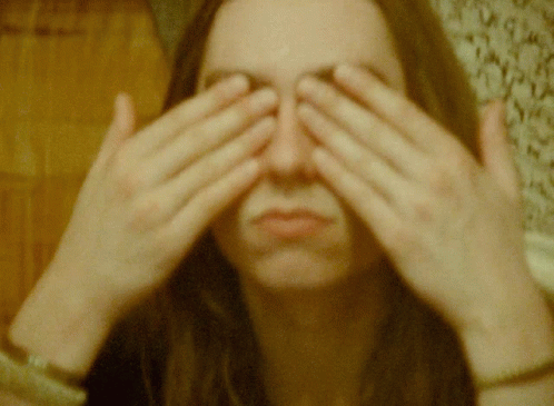 a woman covering her eyes with both hands