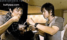 a couple of men are eating food with a tumblr.com logo in the background