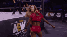 two women are wrestling in a ring with a sign that says aew on it