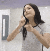 a young woman with long hair is making a funny face while holding her hair .
