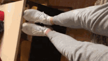 a person wearing white socks and grey pants is standing on a table