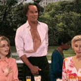 a man in a pink shirt has his shirt open
