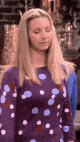 a blonde woman wearing a purple polka dot shirt