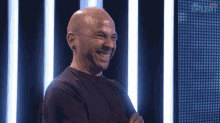 a man in a black shirt smiles in front of a screen that says talent