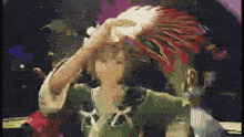 a pixelated image of a person holding a sea shell in their hand
