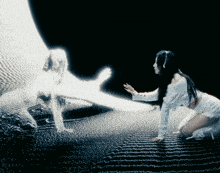 a woman is kneeling down in front of a glowing figure