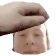a hand is putting a towel on a man 's head .