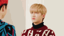 a man wearing a red sweater with the word coca cola on it stands next to another man