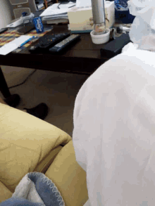 a yellow couch with a blue blanket and a remote control that says ' disney ' on it
