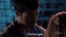 a man is talking to a woman in a dark room and says `` i do love you '' .