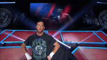 a wrestler wearing a kyle wrestling shirt is standing on a stage