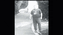 a black and white photo of a man wearing a t-shirt that says ' a ' on it