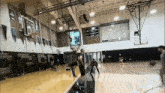 a group of people are playing basketball in a gym with the number 4 on the wall behind them