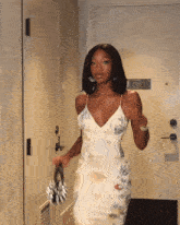 a woman in a white dress stands in a hallway