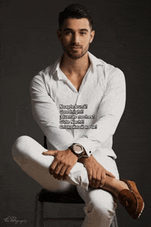 a man in a white shirt sits on a chair with his legs crossed and says goodnight