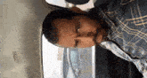a man in a plaid shirt is sitting in the back of a car