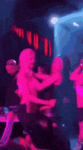 a blurry picture of a group of people dancing in a dark room