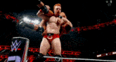 a man is wrestling another man in a wrestling ring with a crowd watching .