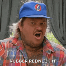 a man wearing a blue hat and plaid shirt is saying rubber redneckin '