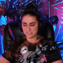 a woman is wearing headphones and holding a stuffed sloth .