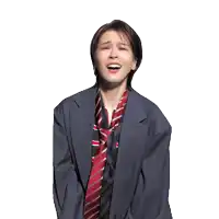 a woman in a suit and tie is smiling with her eyes closed