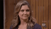 a woman is making a funny face while looking at the camera .