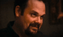 a man with a beard and earrings on his ears