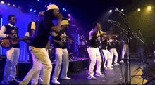a group of men are dancing and singing on a stage and one of them is wearing a shirt that says 21 on it