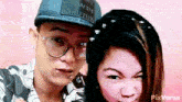 a man and a woman are posing for a picture and the woman is wearing a hat that says " mau tue "